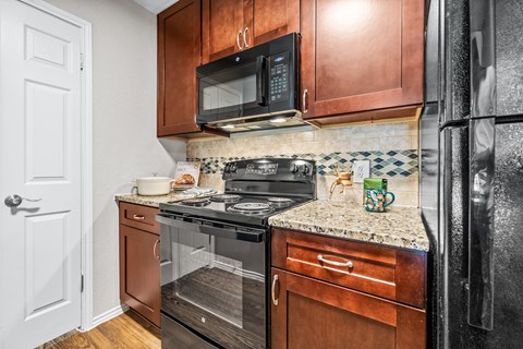a kitchen with black appliances and wooden cabinets