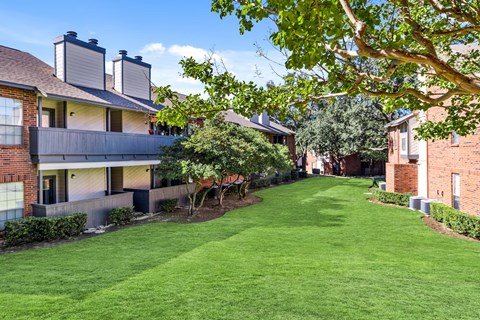 a green lawn in front of some apartments