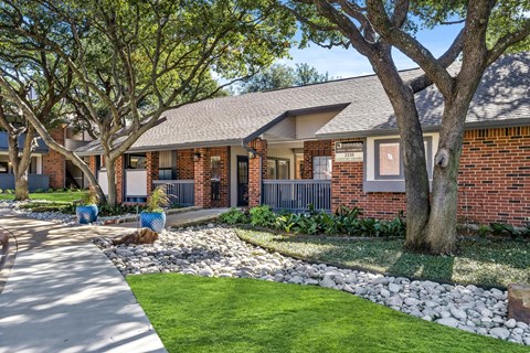 a house with a yard and trees and a sidewalk