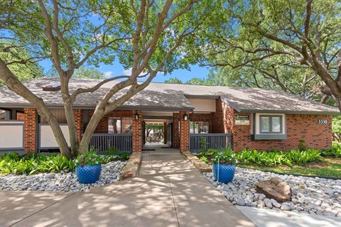 a house with a sidewalk and trees in front of it