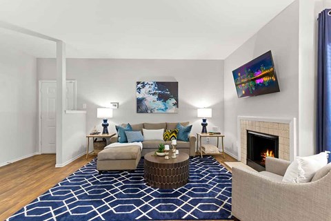 a living room with a fireplace and a blue rug