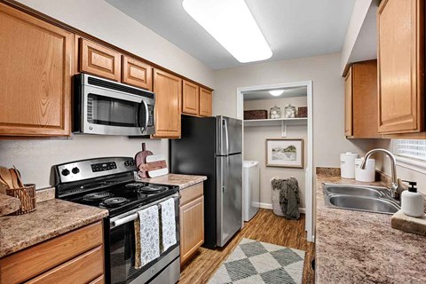 A kitchen with wooden cabinets and a black stove top oven.