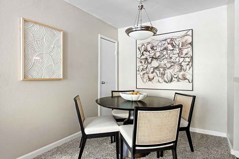 A dining room with a table and chairs.