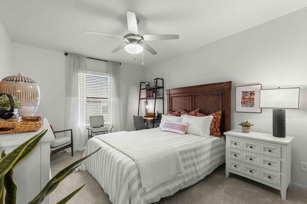 a bedroom with a bed and a ceiling fan