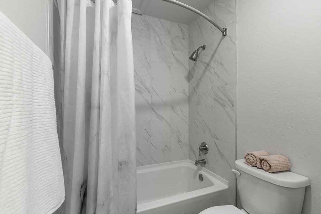 a bathroom with a shower and a toilet and a shower curtain