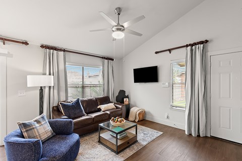 A living room with a blue chair and a brown couch.
