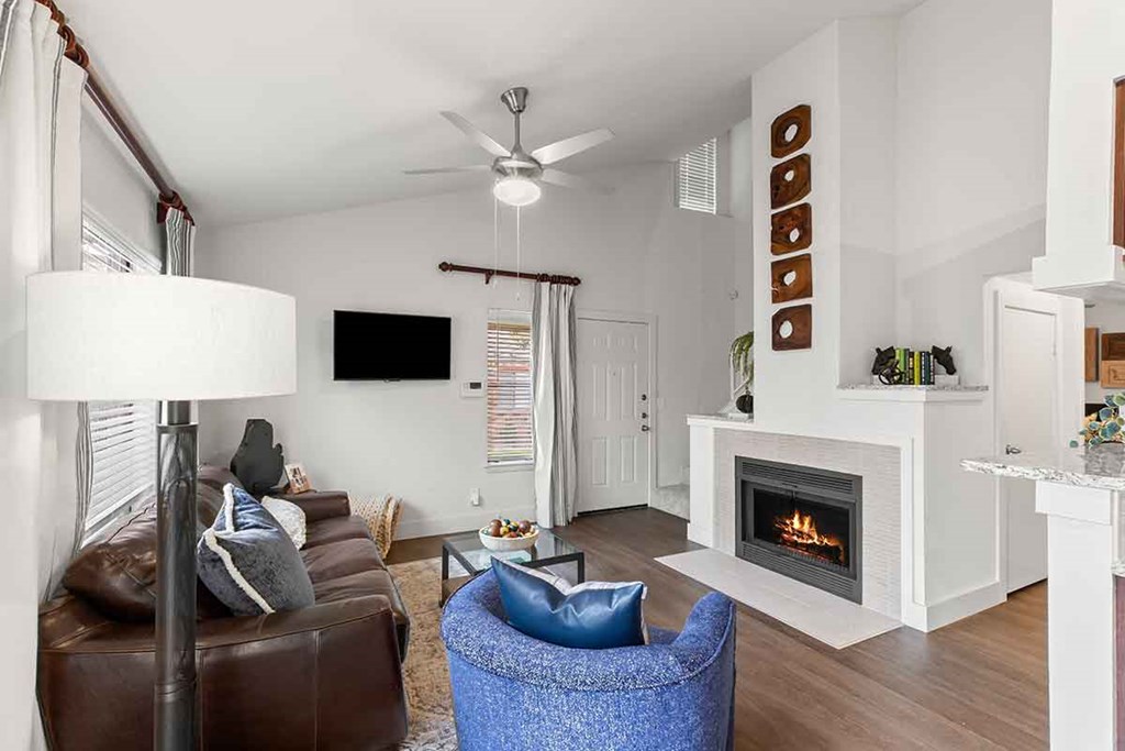 a living room with a leather couch and a fireplace