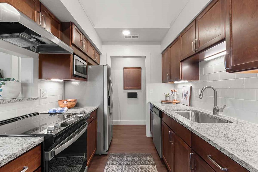 a kitchen with stainless steel appliances and marble counter tops