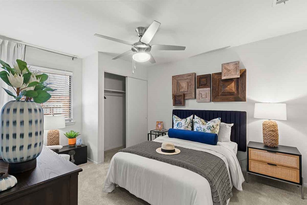 a bedroom with a bed and a ceiling fan