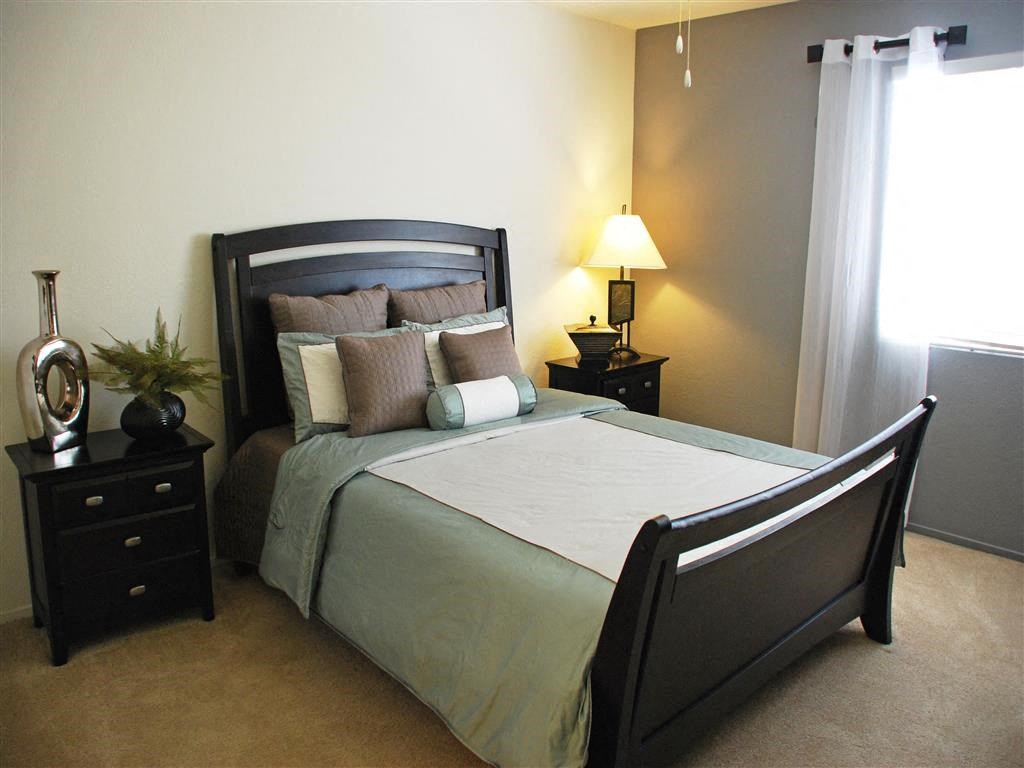 a bedroom with a bed with pillows and a window