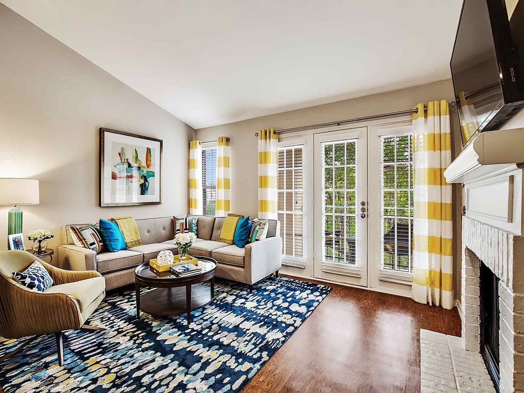 a living room with a fireplace and yellow curtains
