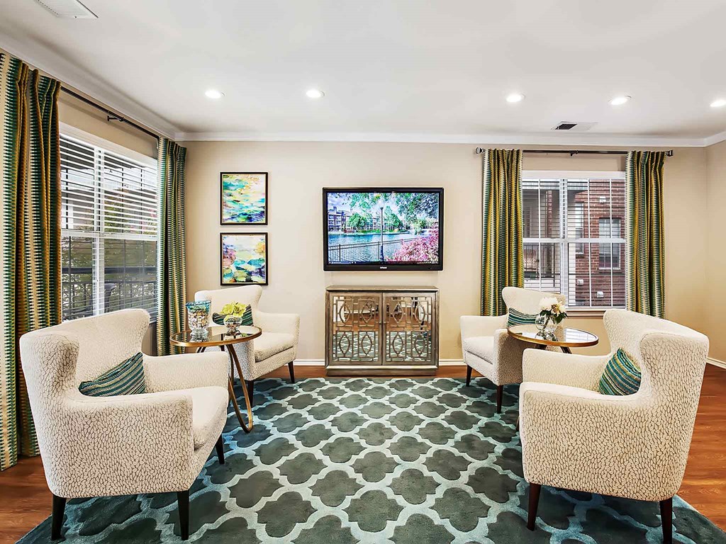 a living room with chairs and a television