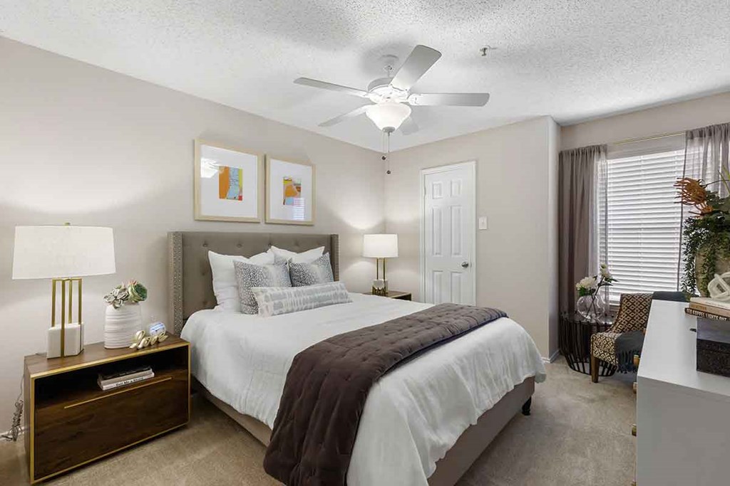 a bedroom with a bed and a ceiling fan