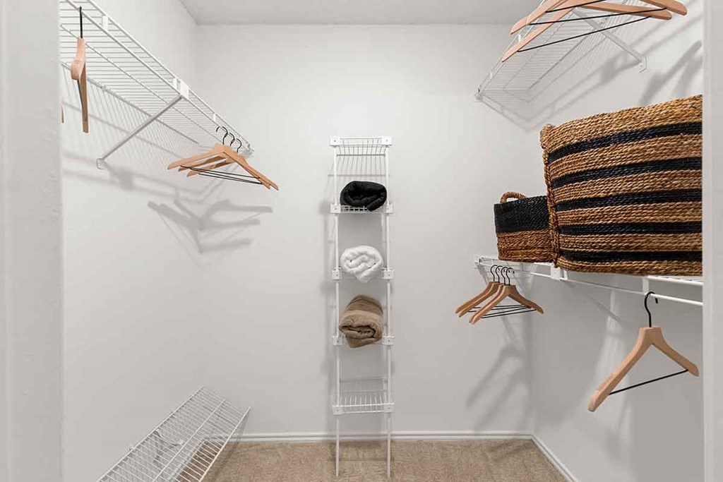 a walk in closet with racks and towels on the wall