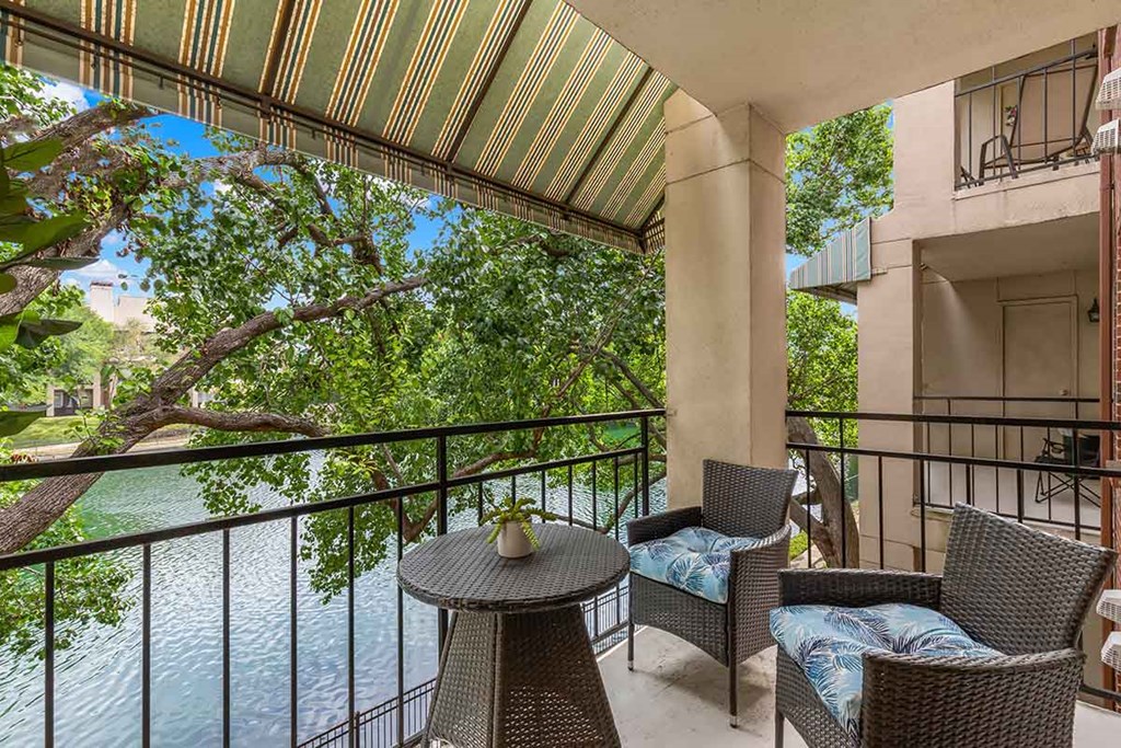 a balcony with a table and chairs overlooking a river