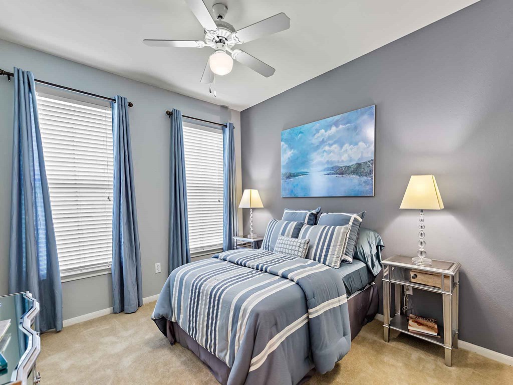 a bedroom with a bed and a ceiling fan