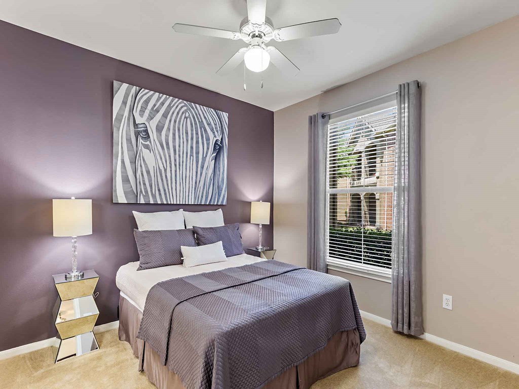 a bedroom with a bed and a ceiling fan