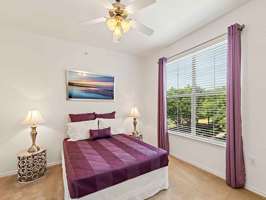 a bedroom with a bed and a ceiling fan