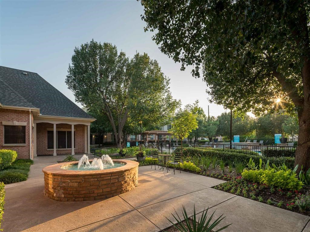 a courtyard with a fountain in front of a building