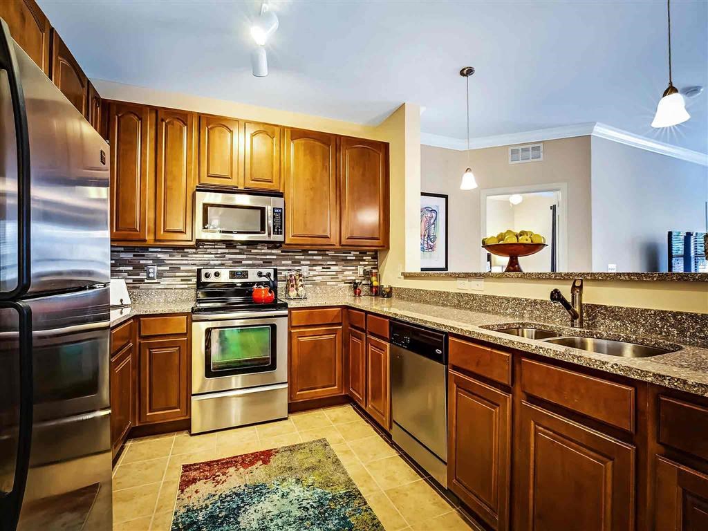 a large kitchen with stainless steel appliances and wooden cabinets