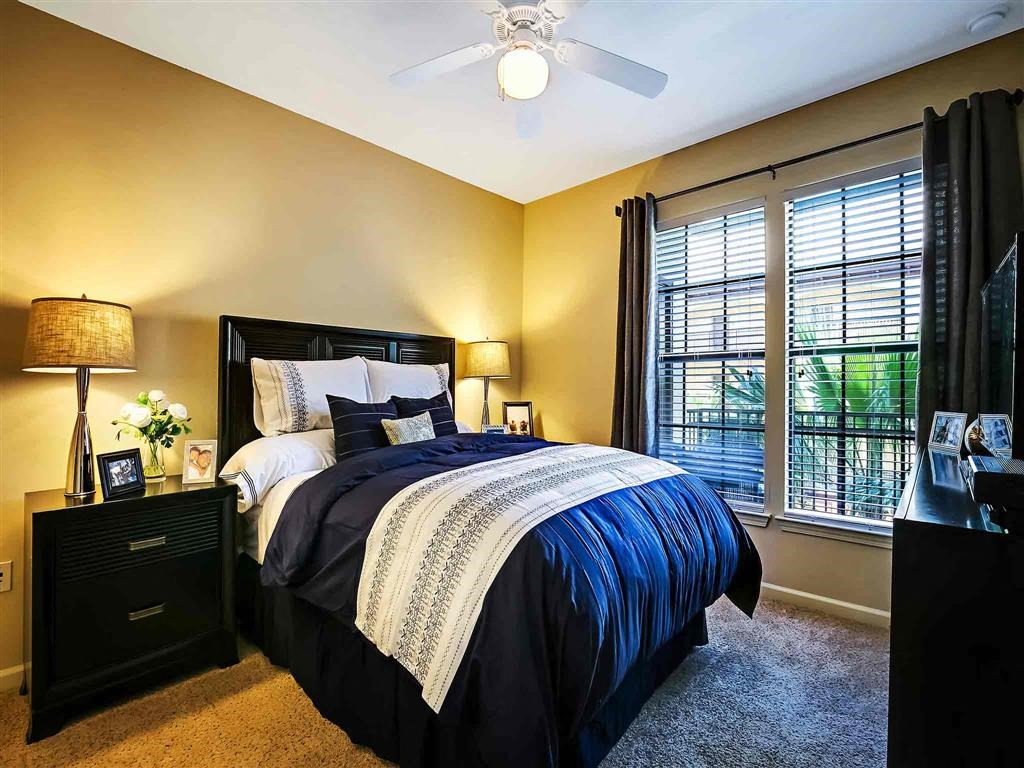 a bedroom with a bed and a ceiling fan