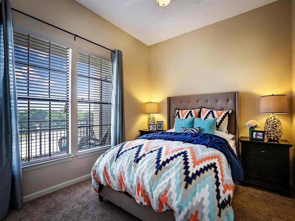 a bedroom with a bed and two windows