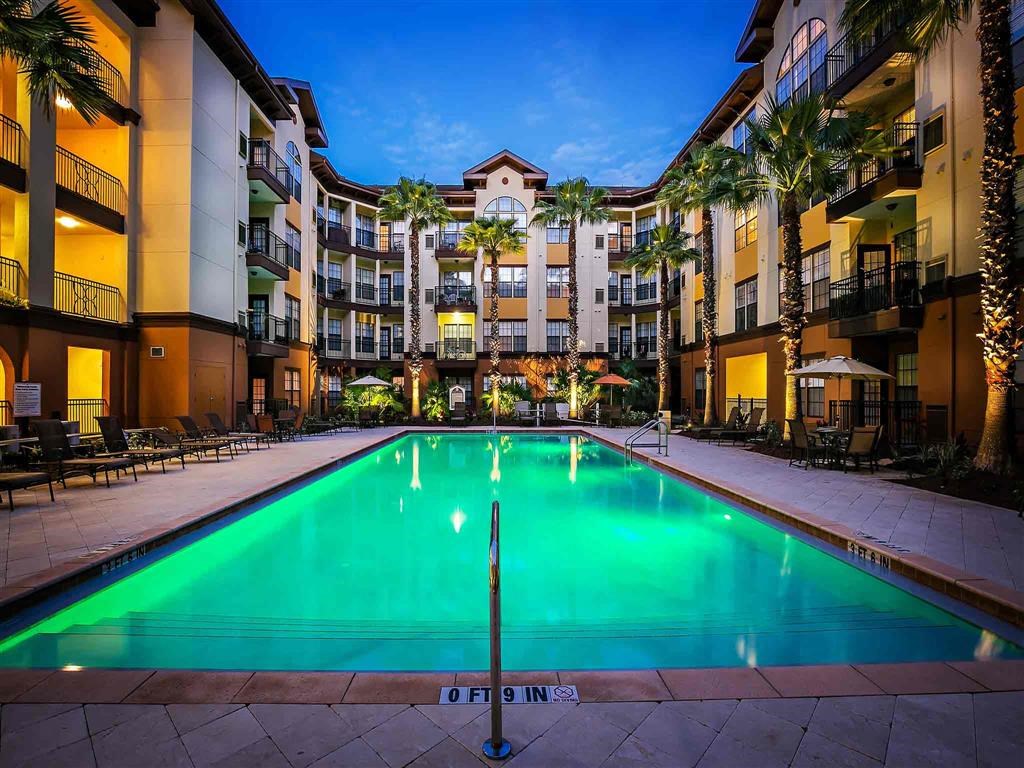the swimming pool at night at the grove apartments