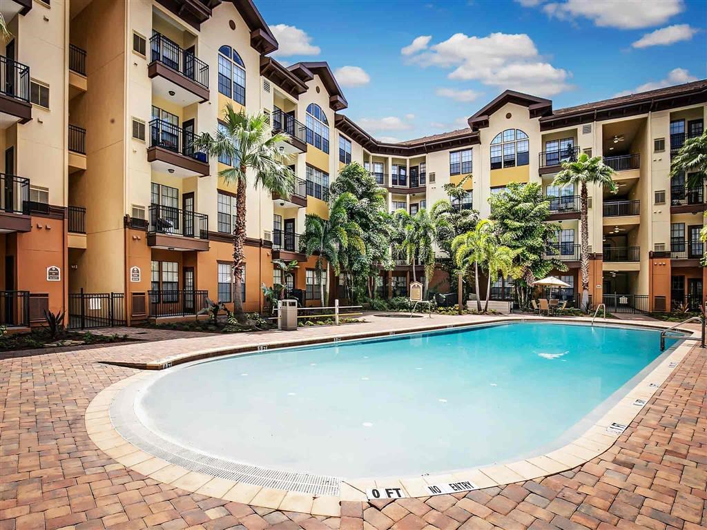 an outdoor swimming pool with an apartment building in the background