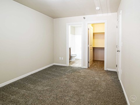 a room with a carpeted floor and a door to a bathroom