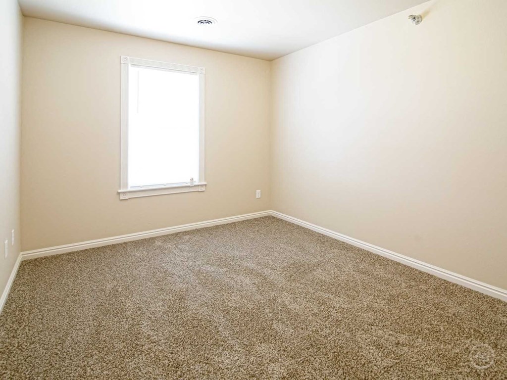 an empty room with carpet and a window