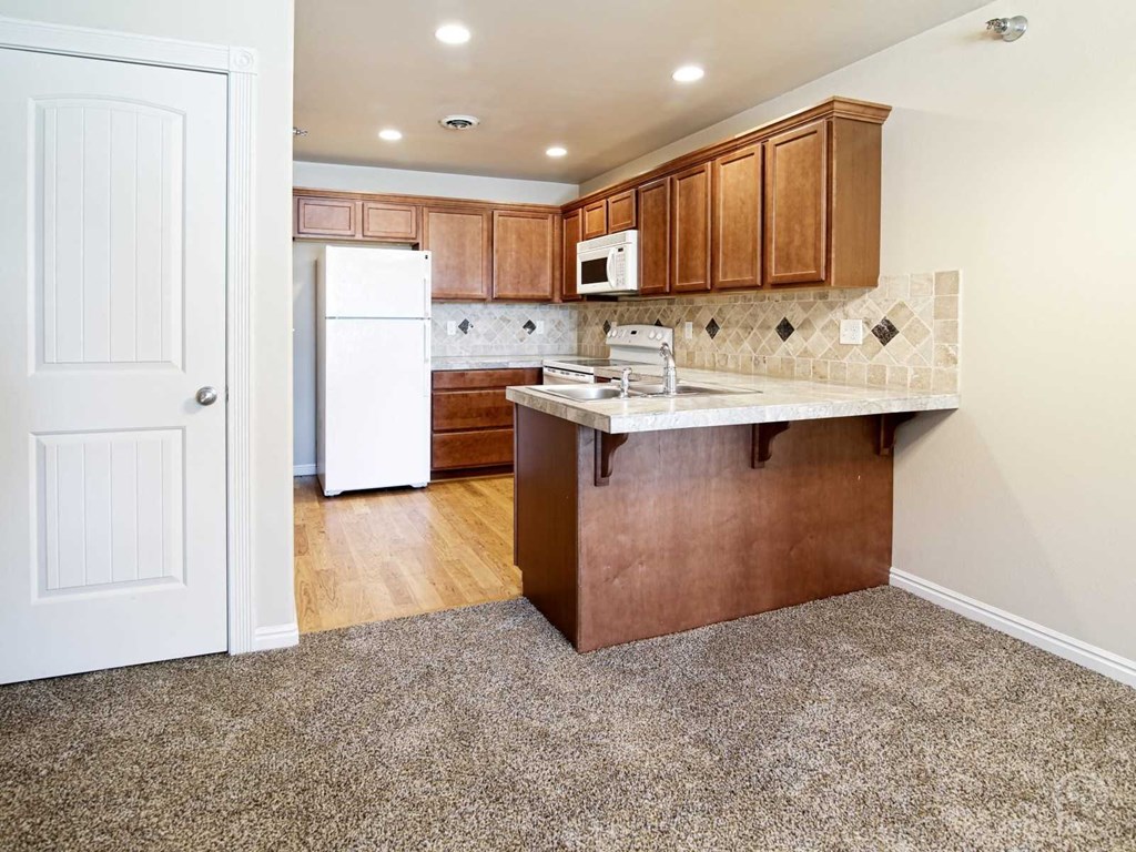 a kitchen with wooden cabinets and a white refrigerator