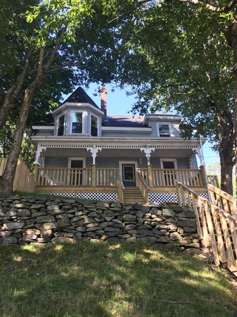 A house with a stone wall in front.