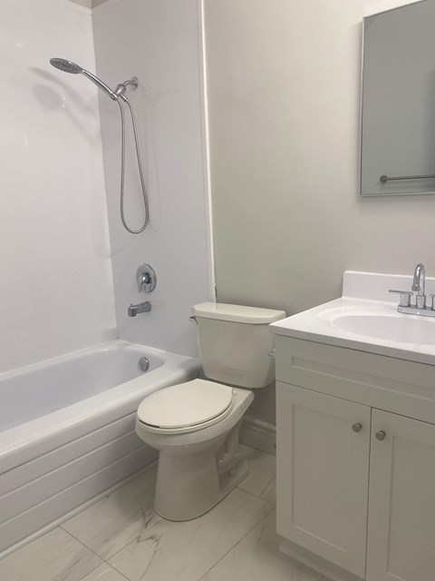 A white toilet sits next to a white sink in a bathroom.