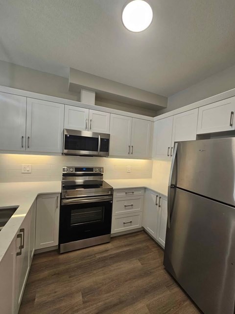A kitchen with a stainless steel refrigerator and oven.