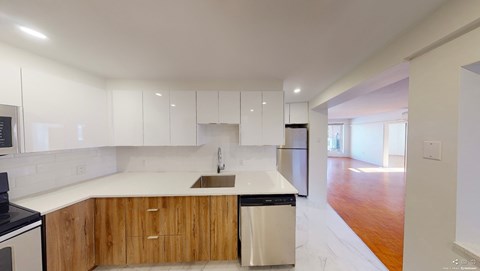 A modern kitchen with wooden cabinets and a white countertop.