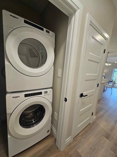 Two white Whirlpool washing machines in a laundry room.