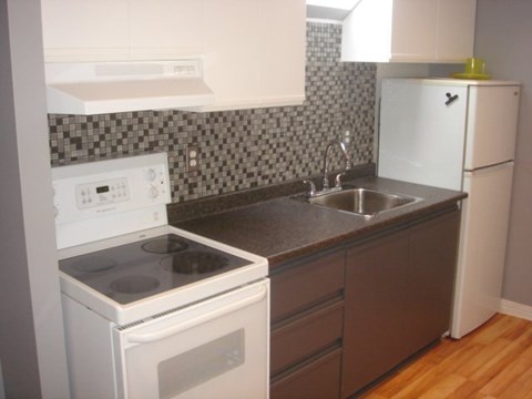 A kitchen with a white oven and a white fridge.