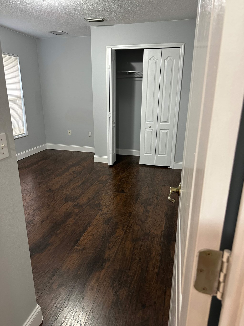 A room with a white door and a wooden floor.