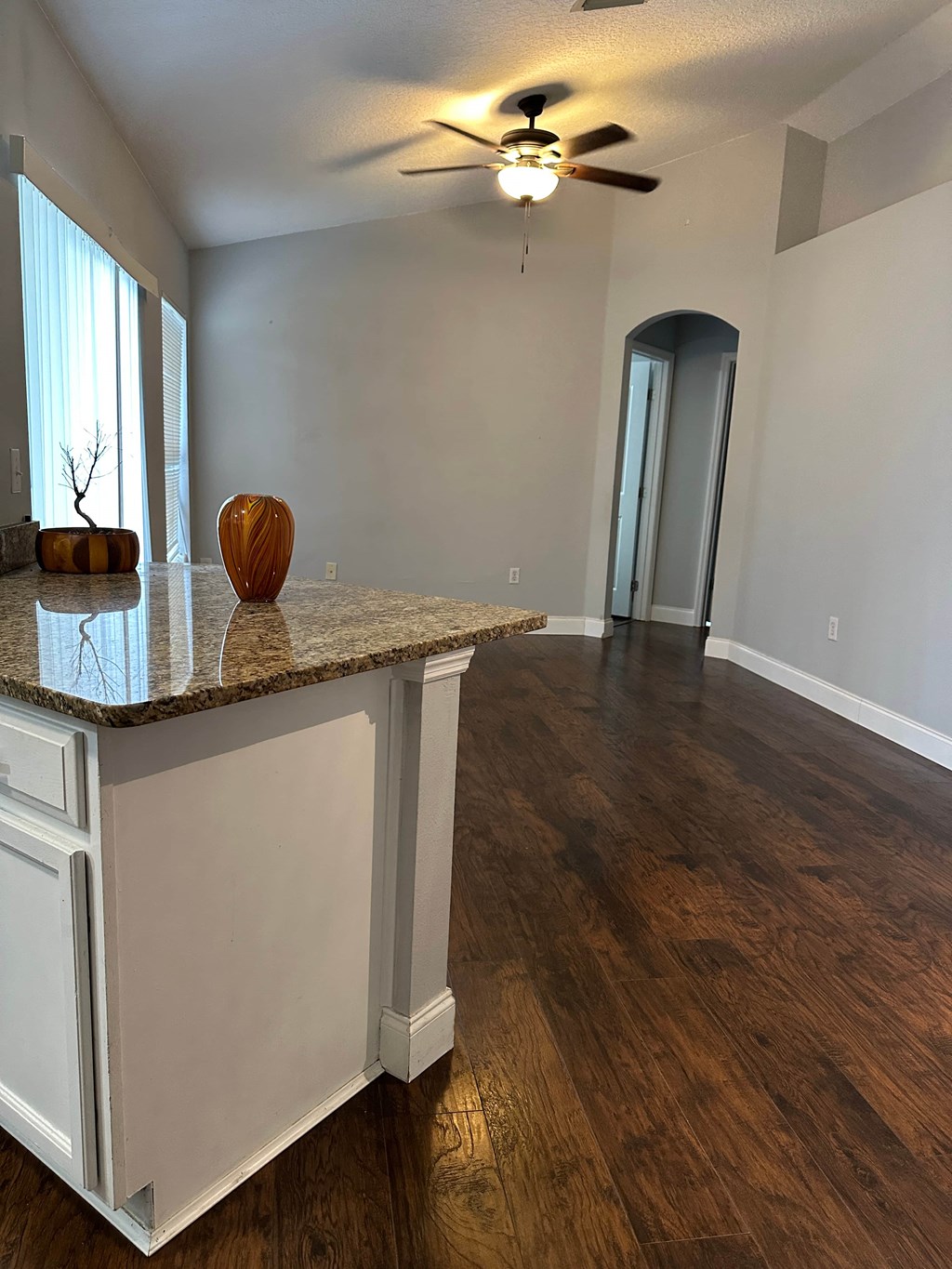 A room with a marble countertop and a ceiling fan.