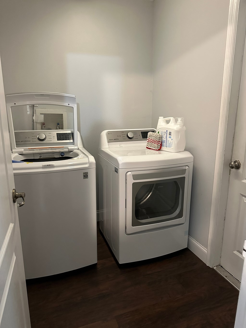 Two white ovens, one with a door open, in a small room.