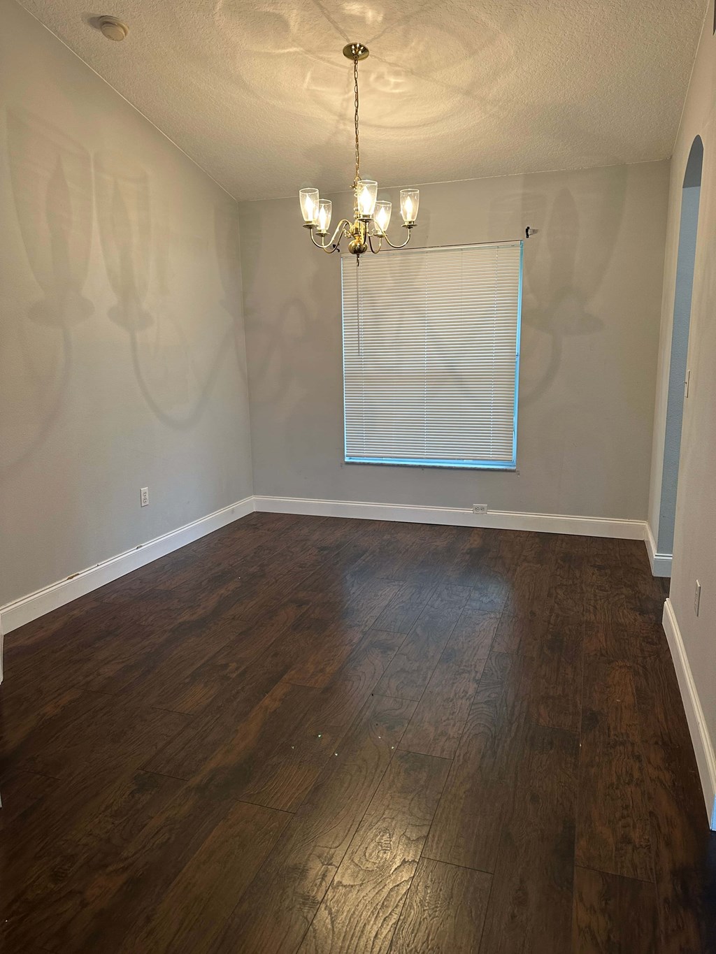 A room with wooden floors and a chandelier.