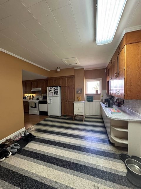 A kitchen with a striped rug on the floor.