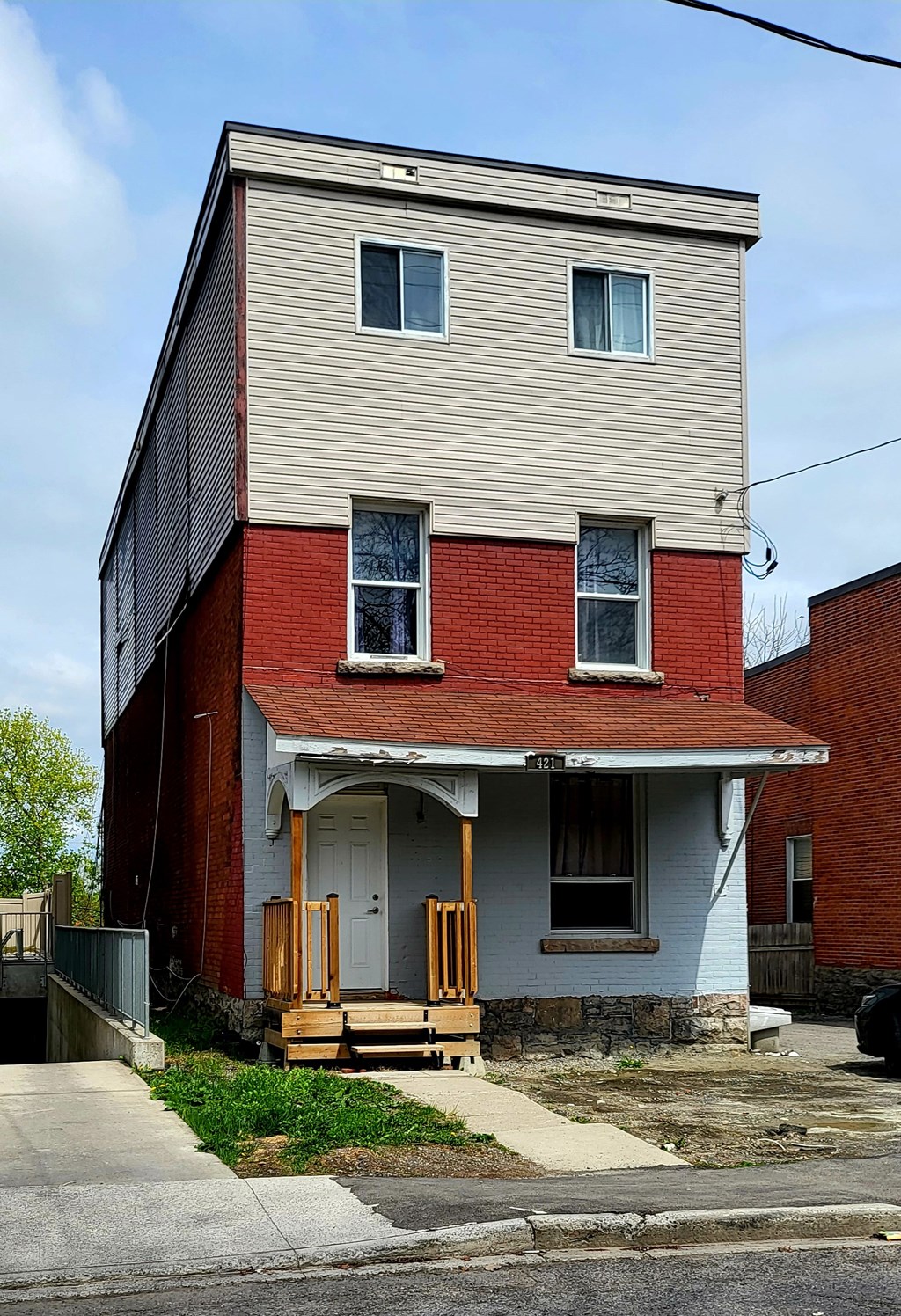 A two-story house with a red brick base and a beige upper level.