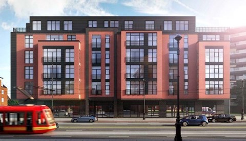 A red and black building with a tram in front.
