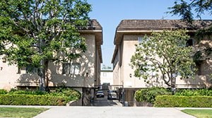 A car is parked in the driveway of a two-story house.