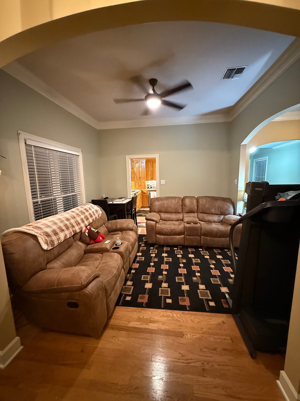 A living room with a brown couch and a black television.