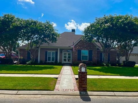A house with a brick mailbox in front of it.
