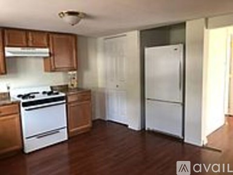 A kitchen with a white stove top oven and a white refrigerator.