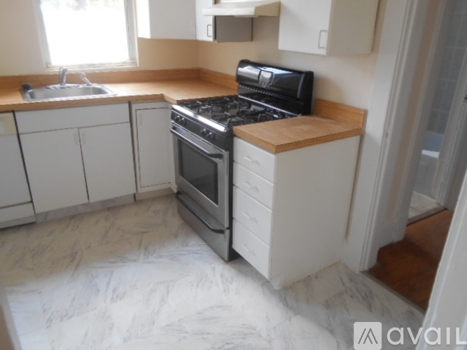 A kitchen with a black stove top oven and white cabinets.
