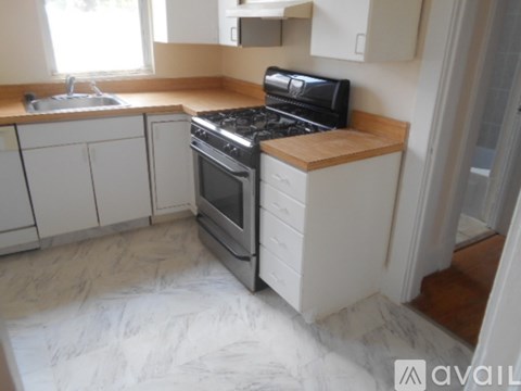 A kitchen with a black stove top oven and white cabinets.